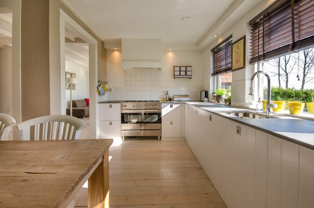 A kitchen with sun shining through windows