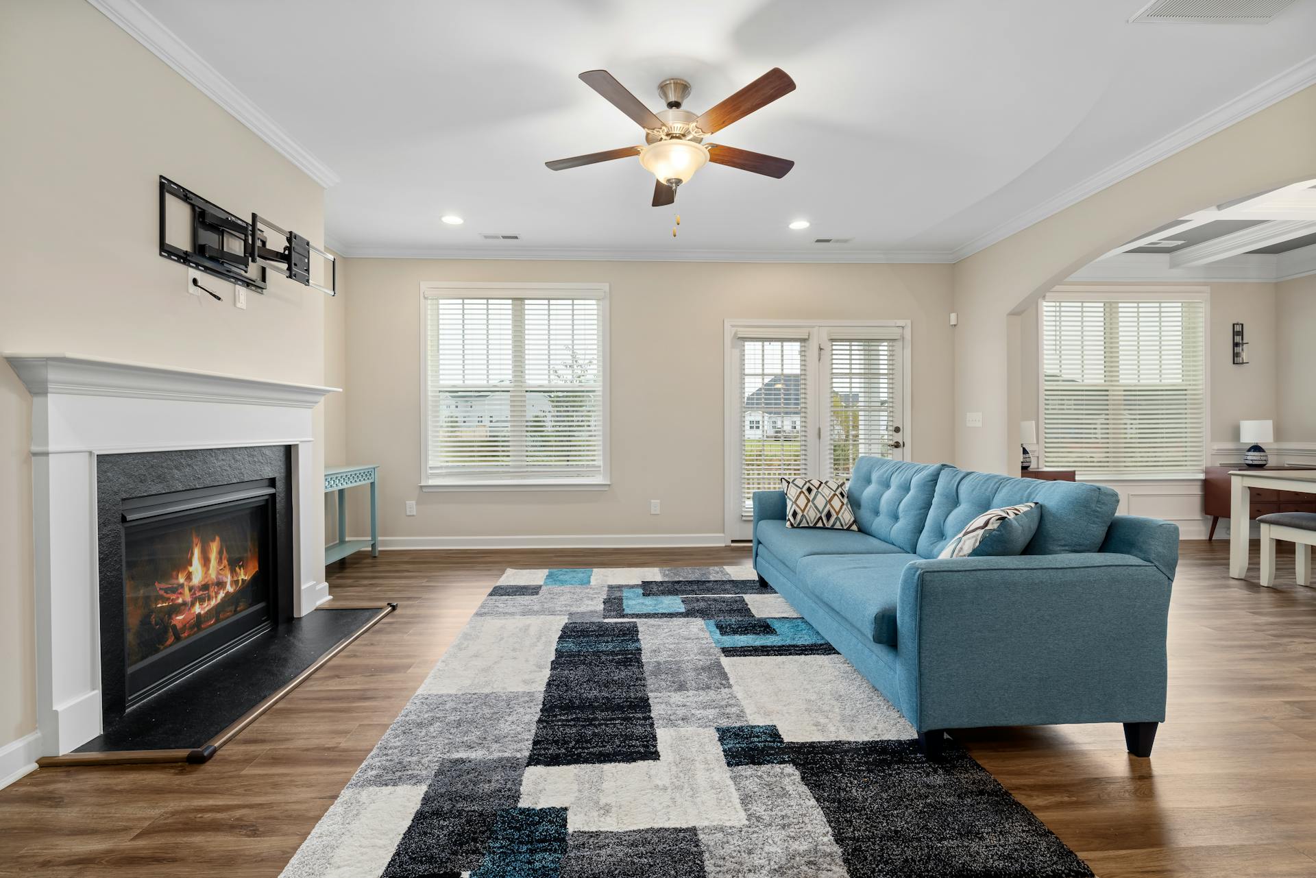 A beautiful bare modern living room with a blue couch and a fireplace