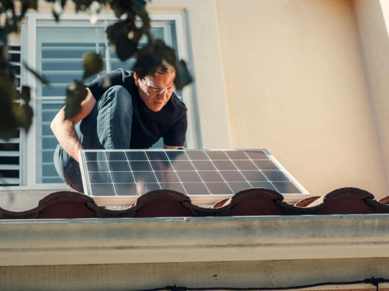 Man installing a solar panel on the roof