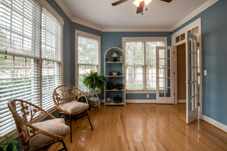 A blue painted sun room with large windows
