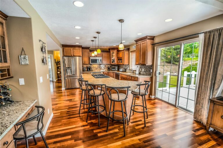 A large kitchen with an island in the middle with barstools